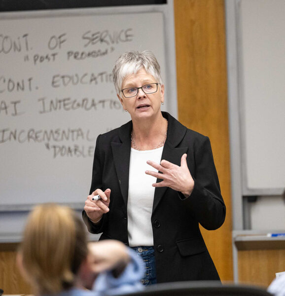 Babson entrepreneurship professor Heidi Neck at the front of a classroom teaching entrepreneurship teachers.