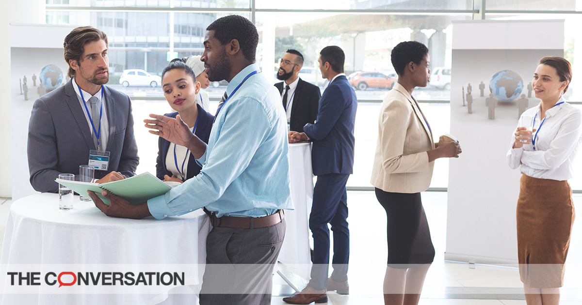 Employees discuss over documents at table during a company retreat