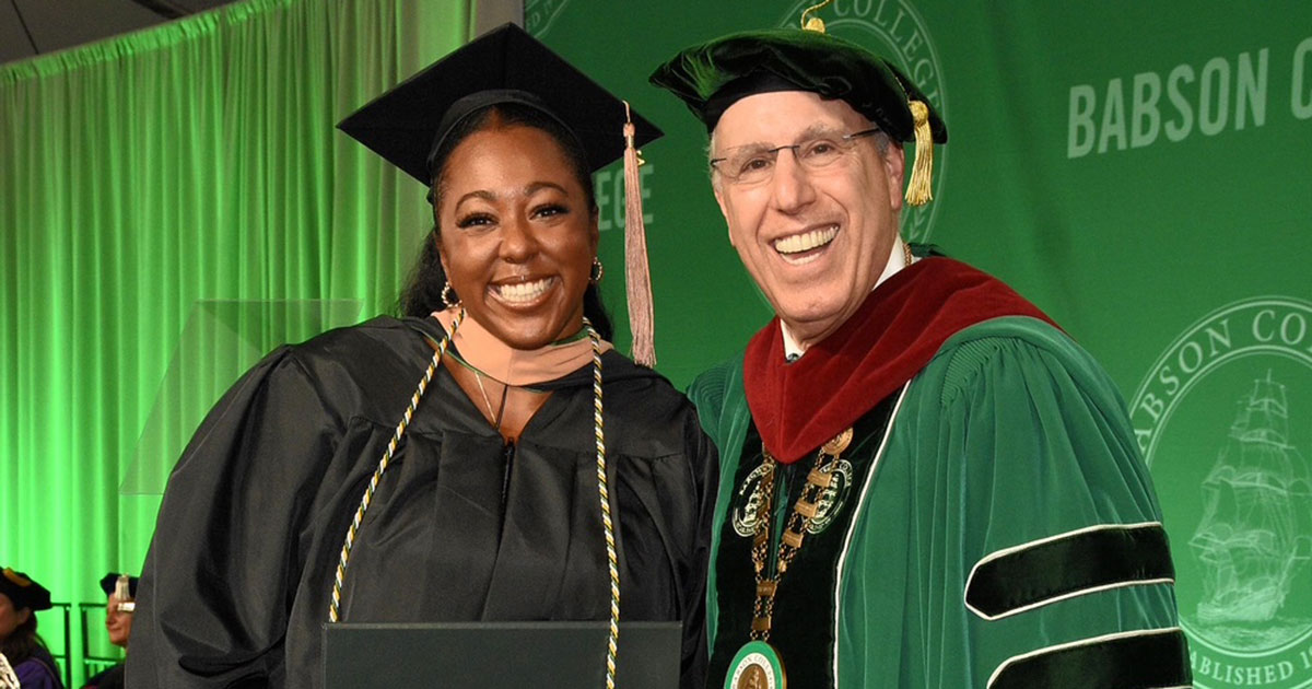Aymbré Paige MBA’25 and Babson President Stephen Spinelli Jr. MBA’92, PhD stand on stage at Commencement
