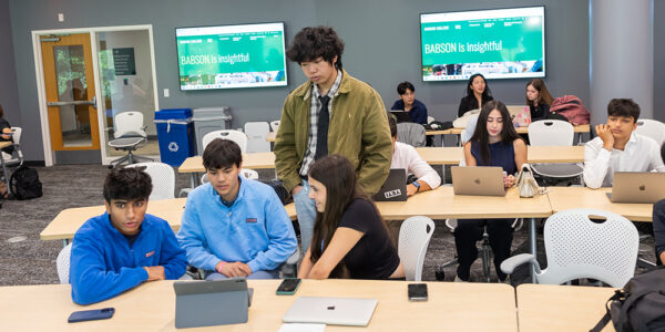 Students work together at tables during a Summer Study pitch preparation session