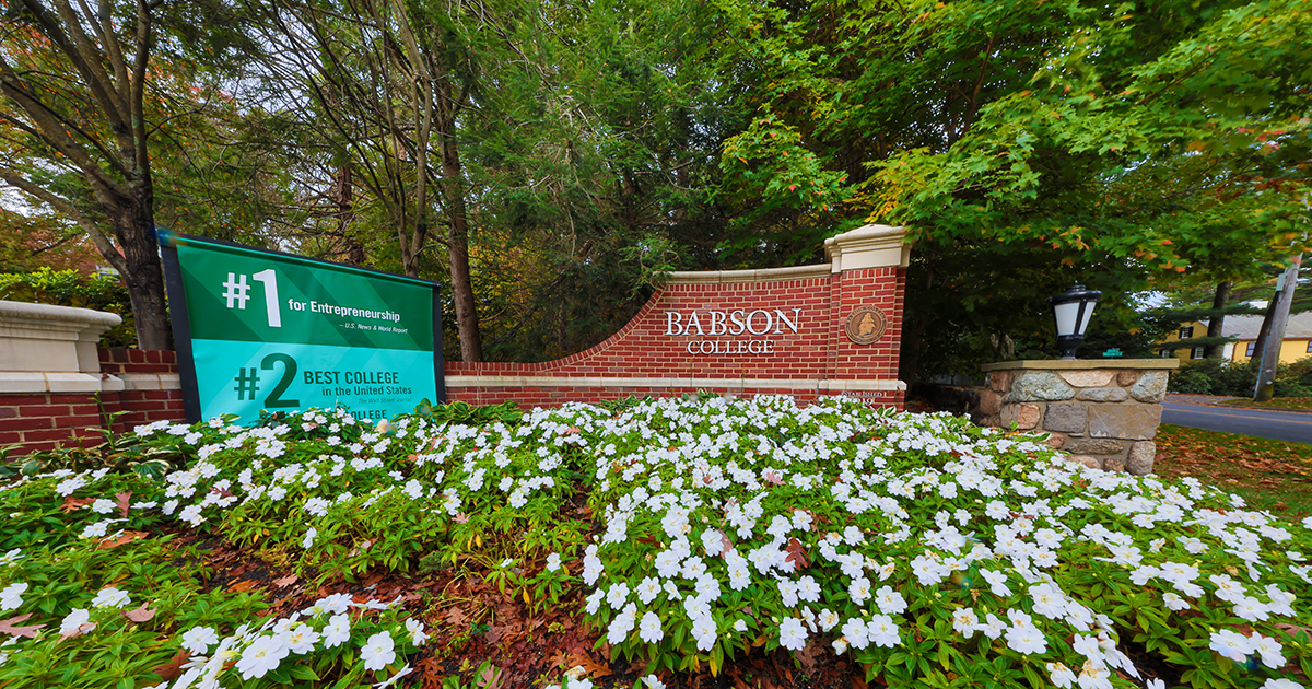 Babson's front gate with flowers and a sign reading No. 1 in Entrepreneurship