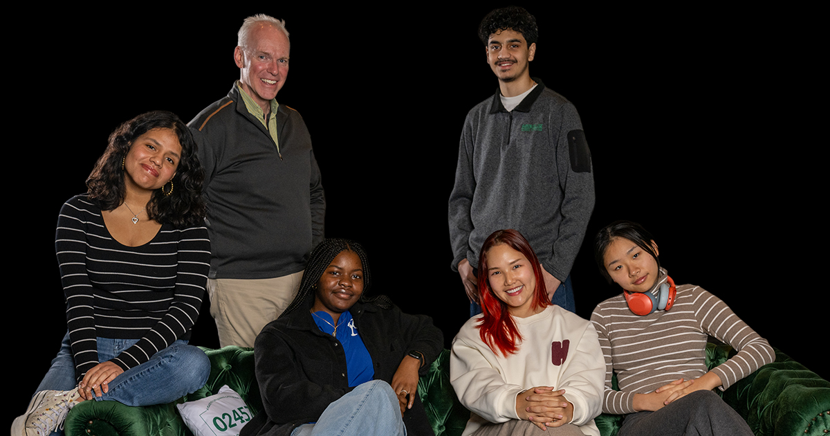 Four women who are cast members of Project Empathy sit on a couch, a man who is the director and a male student cast member stand behind the couch.