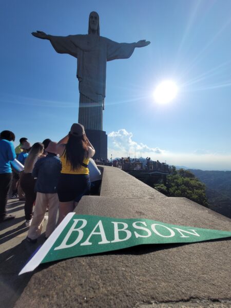 The Babson flag in front of the Christ the Redeemer statue