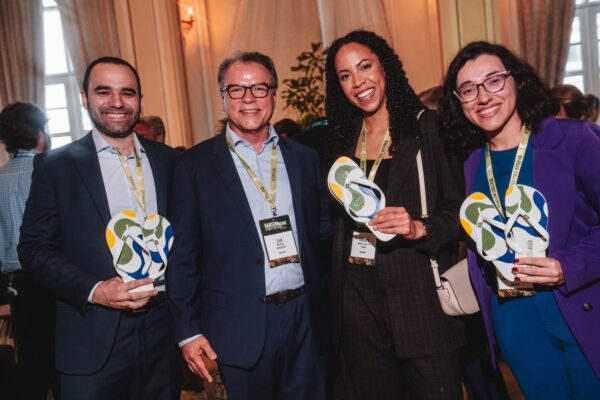 Liel Miranda with three panelists holding up Brazilian flip flops
