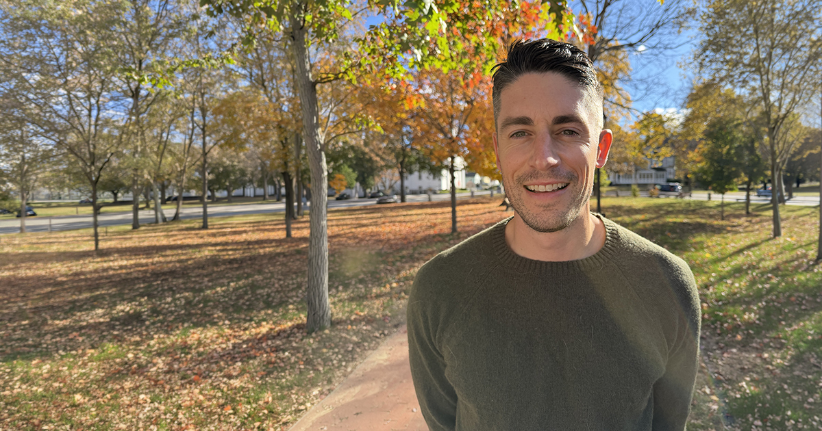 Brendan McGill poses for a portrait outside amid a beautiful fall landscape