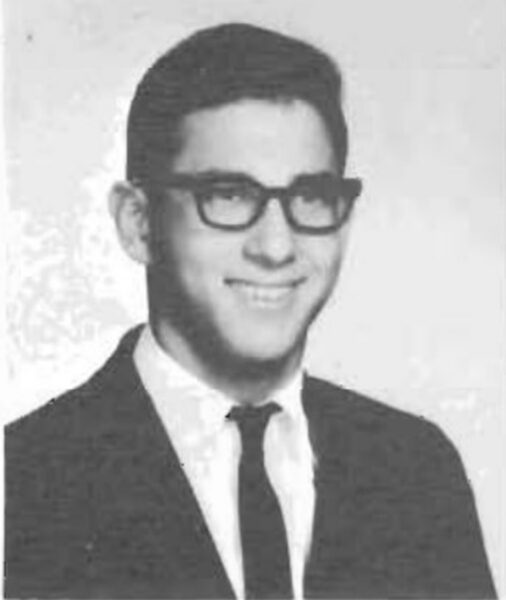 Man smiling in black and white photo from 1964 yearbook.