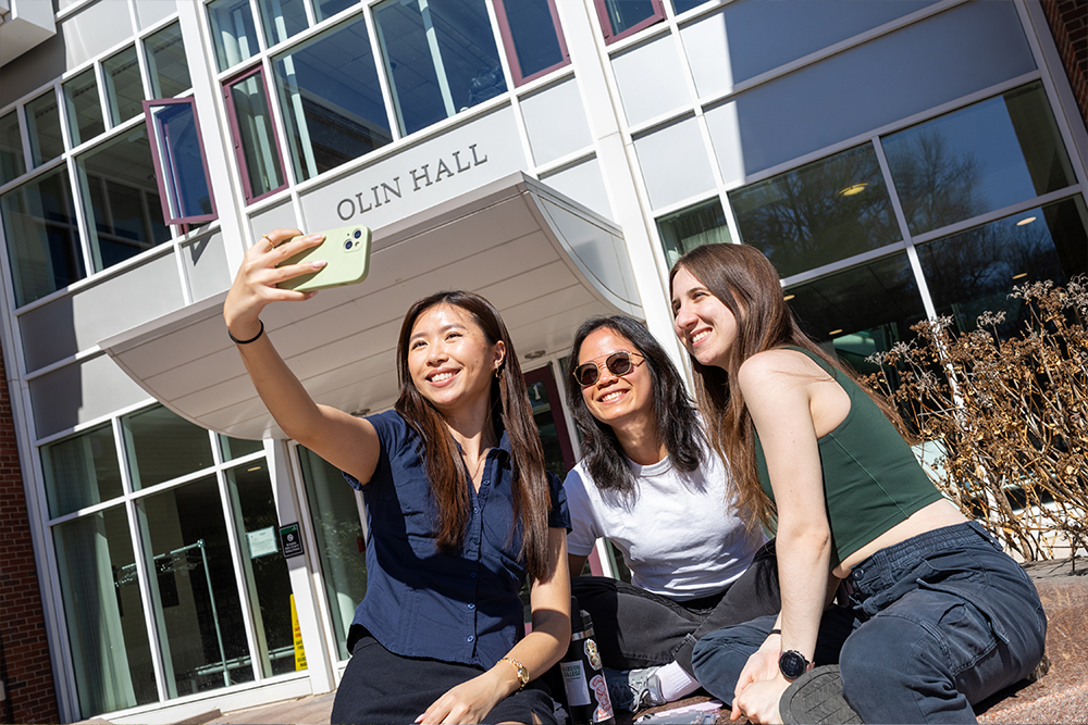 Three students pose for a selfie outside Oline Hall