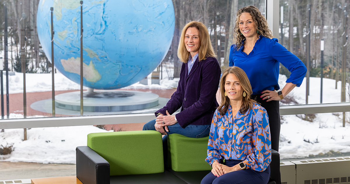 The three sisters pose for a portrait with the Babson World Globe in the background