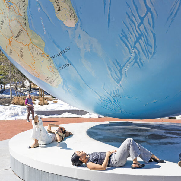 Students sunbathe under the Babson World Globe