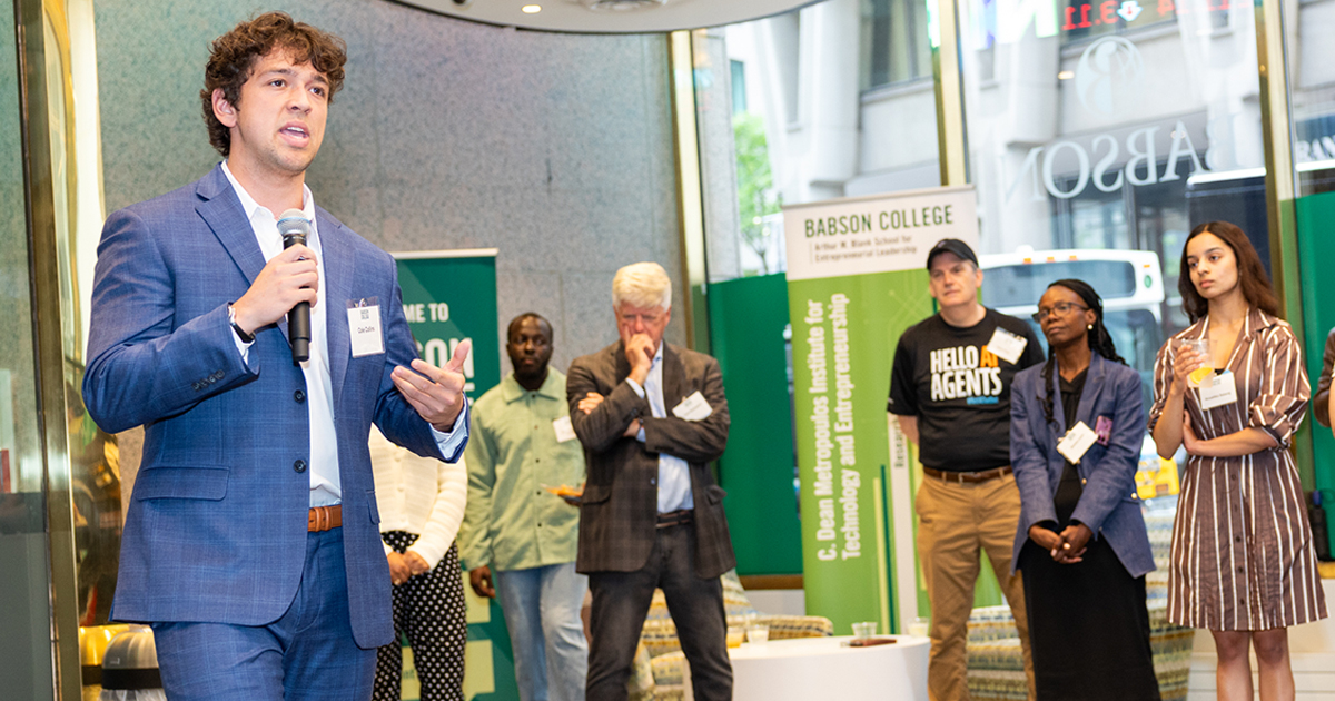 A student speaks at an event with others standing nearby