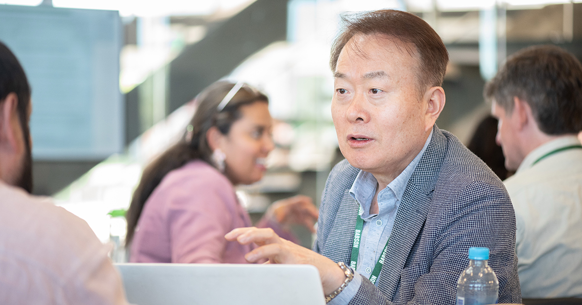 John Yun gestures while speaking with a colleague