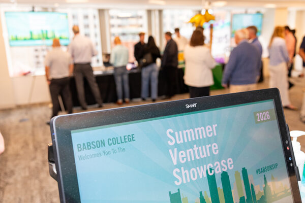 A laptop screen displays the logo for the Summer Venture Showcase