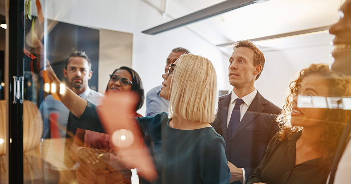 Group of diverse office colleagues brainstorming together, exhibiting teamwork as one of the skills favored by employers..