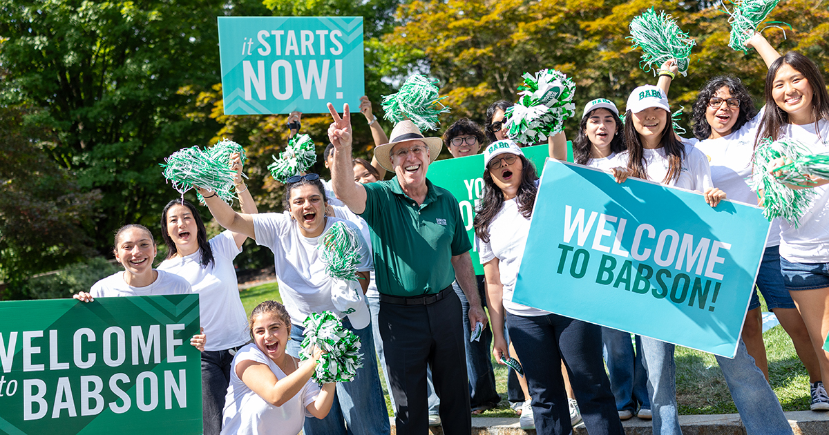 President Spinelli and a group of students cheer at the College's entrance