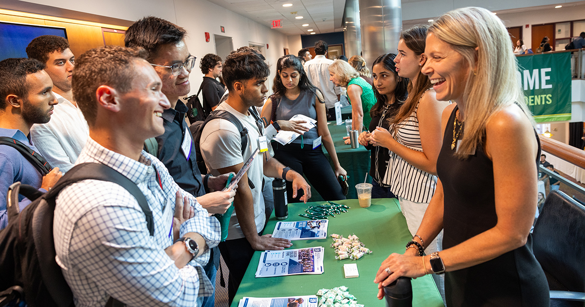Students talk at a table an an orientation event
