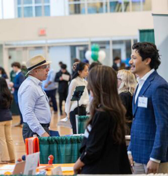 Two men talking at Babson career fair.