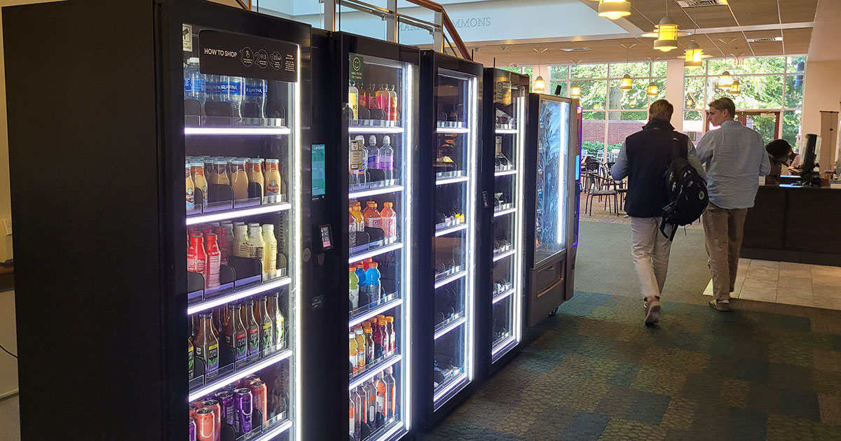 Two students stroll by a line of vending machines