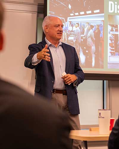 Brett Jewkes motions while speaking to the class