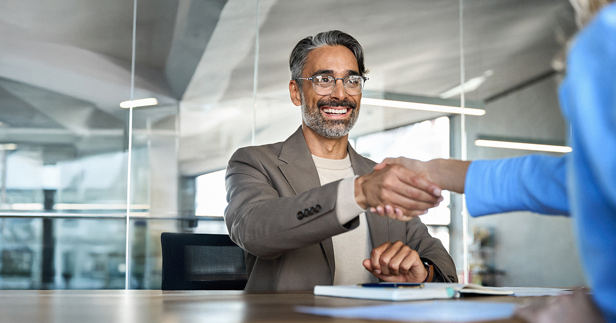Mature smiling happy professional business man executive, male hr recruiter or bank manager hiring recruit at job interview onboarding corporate office meeting. Handshake with new client concept.
